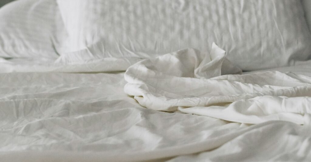 Calm bed with white linens and soft morning light