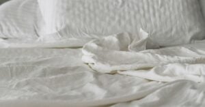 Calm bed with white linens and soft morning light