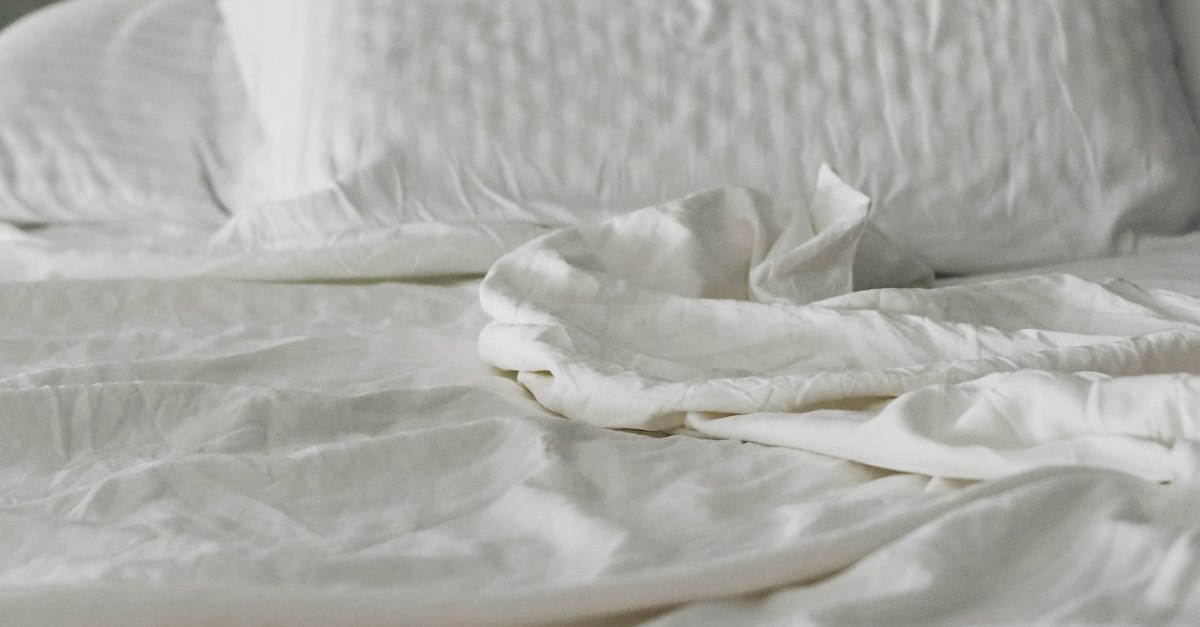 Calm bed with white linens and soft morning light